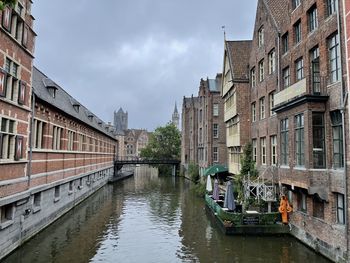 Canal amidst buildings against sky in city