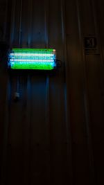 Low angle view of illuminated lighting equipment on wall