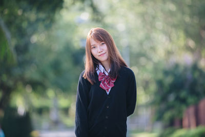 Portrait of beautiful young woman standing outdoors