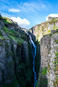 Scenic view of waterfall against sky