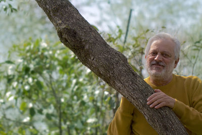 Portrait of man on tree trunk