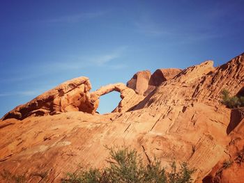 Low angle view of rock formations against blue sky