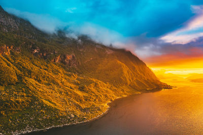 Scenic view of fjord against sky during sunset