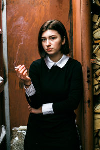 Portrait of young woman holding cigarette