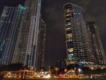 Low angle view of illuminated buildings against sky at night