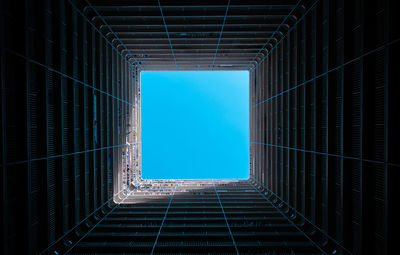 Directly below shot of building against blue sky