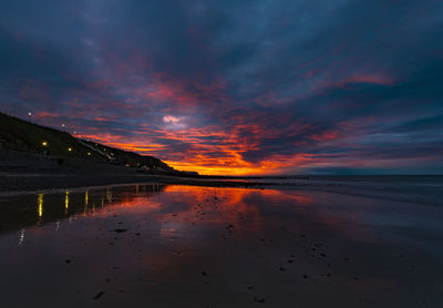 Scenic view of sea against dramatic sky during sunset