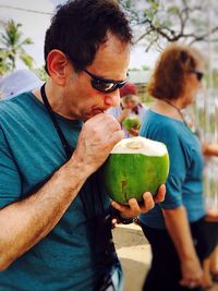 Man drinking coconut outdoors