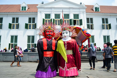 Group of people on street against buildings in city