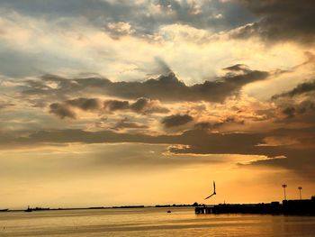 Scenic view of sea against dramatic sky during sunset