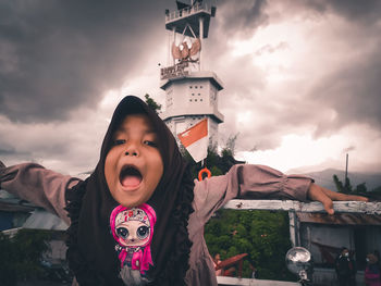 Portrait of happy girl against sky