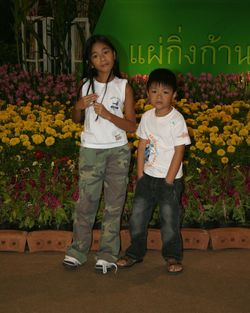 Full length of siblings standing on flower