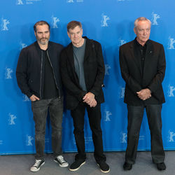 Portrait of friends standing against blue wall