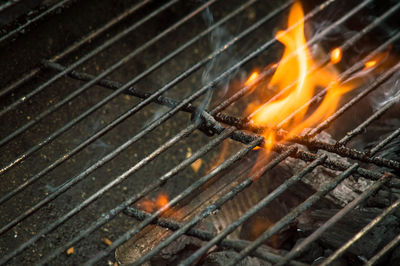 Close-up of fire on barbecue at night