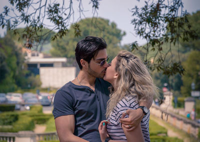 Young couple kissing while standing at park