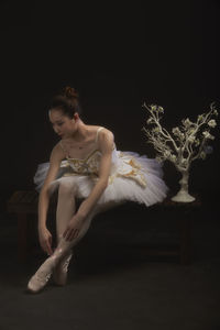 Woman looking away against black background