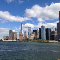 Sea by buildings against sky in city