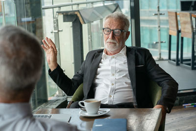 Portrait of man with coffee sitting on table