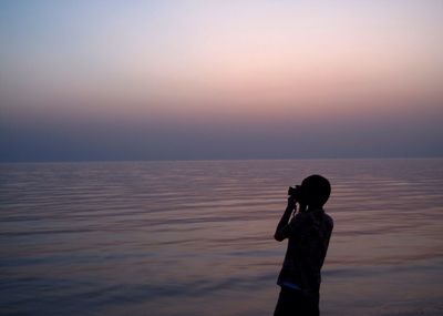 Silhouette of woman looking at sea