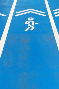 High angle view of disabled sign on blue road