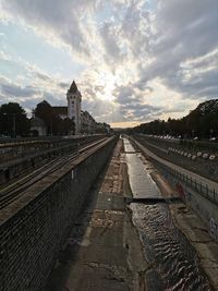 Railroad tracks amidst buildings in city against sky