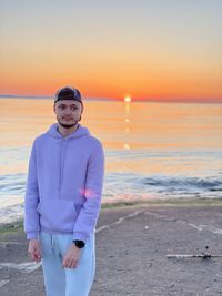 Portrait of man standing on beach during sunset