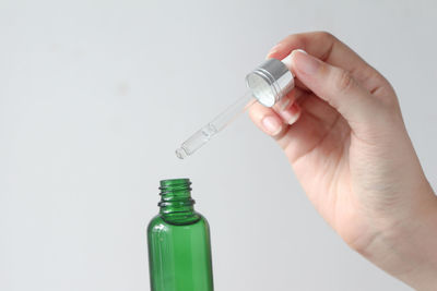 Cropped hand holding dental equipment against white background
