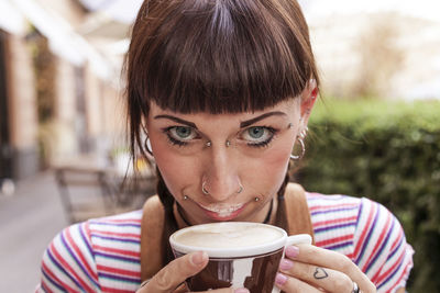 Portrait of young woman drinking coffee