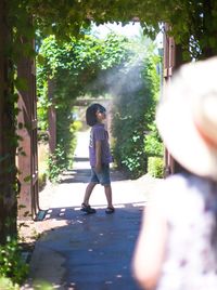 Full length rear view of siblings walking outdoors