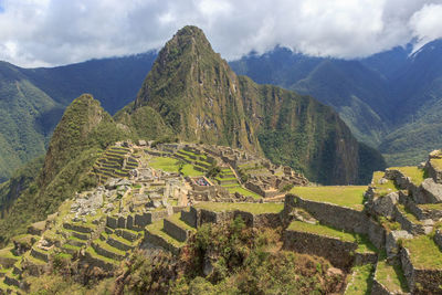 Panoramic view of green mountains against cloudy sky