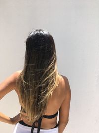 Rear view of woman standing against wall