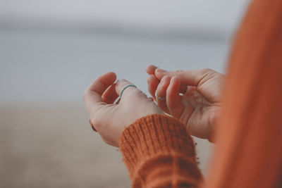 Close-up of woman wearing finger rings at beach
