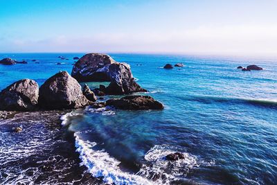 Scenic view of rocks in sea against sky