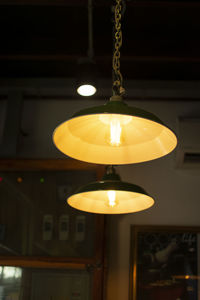 Low angle view of illuminated pendant light hanging from ceiling