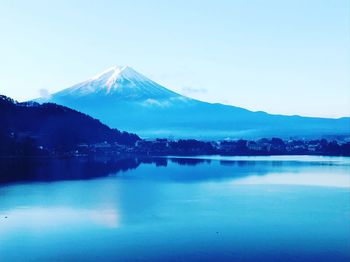 Scenic view of lake and snowcapped mountains against clear sky