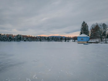 Scenic view of snow covered trees and houses against sky