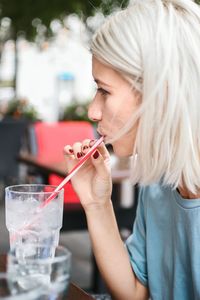 Close-up of young woman holding drink