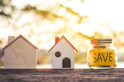 Close-up of stacked coins with model home on table