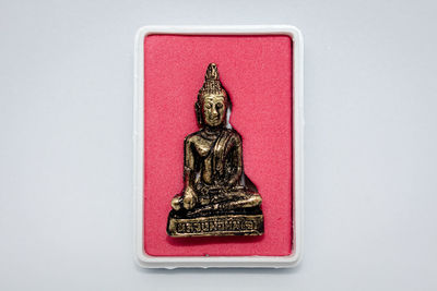 Close-up of buddha statue against white background