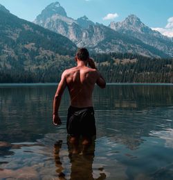 Rear view of shirtless man in lake