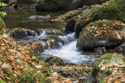 View of stream flowing through rocks