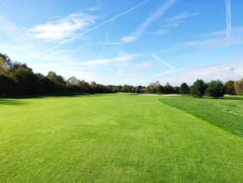 Scenic view of golf course against sky