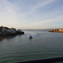 Scenic view of sea against sky in city