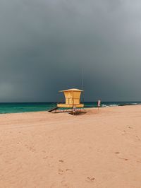 Lifeguard hut on beach against sky