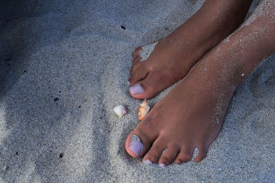 Low section of woman on sand