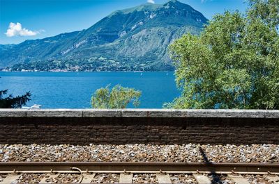 Railroad tracks by mountains against sky