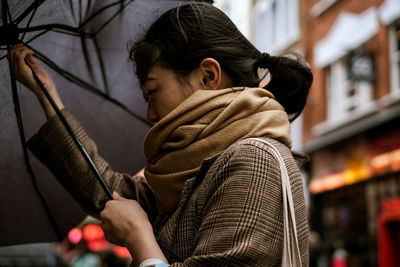 Side view of woman using mobile phone outdoors