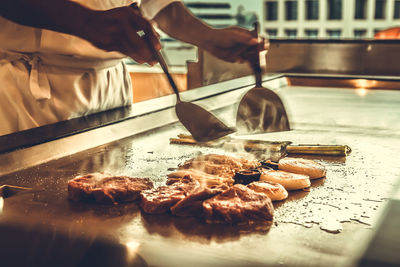 Midsection of person preparing food in kitchen