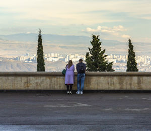 Rear view of people standing on mountain road