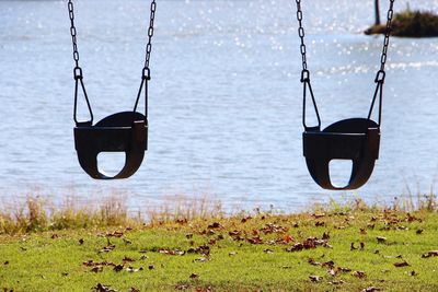 Swings hanging against lake